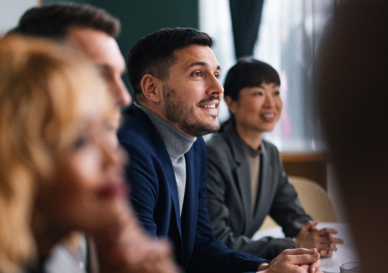 Office workers attending a meeting and sitting at table