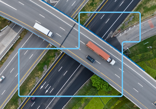 Aerial view of a busy highway filled with various cars and trucks traveling in both directions.
