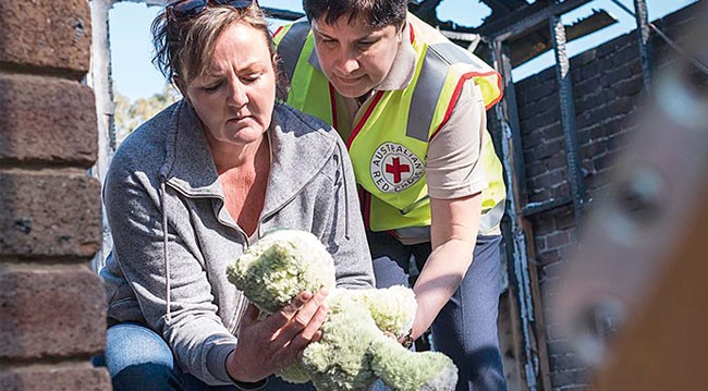 A woman picked up a damaged toy in a burnt-out building