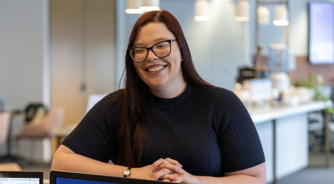 An AICD staff member smiling at a reception desk
