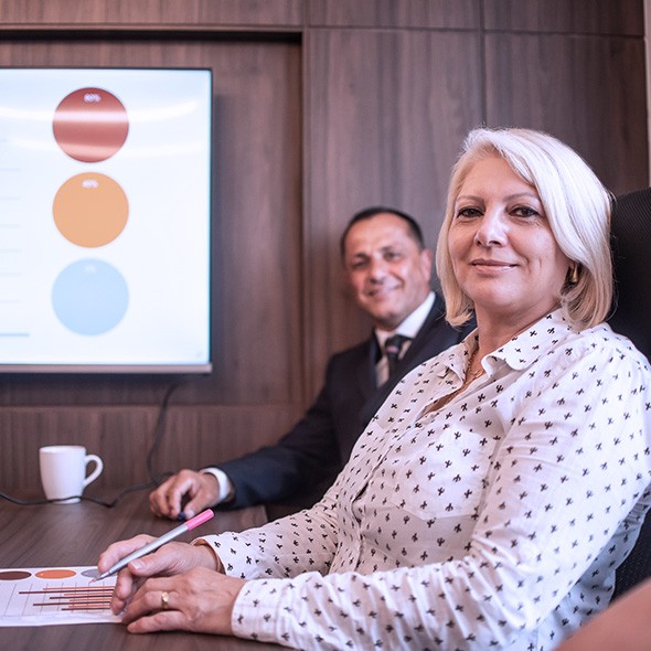two business people smiling in boardroom