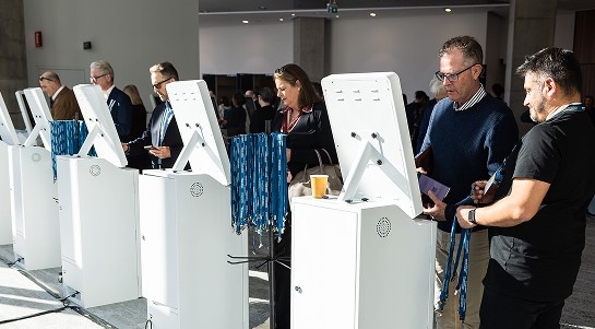 A diverse group of people standing in line to register for an in-person event.