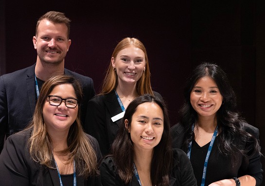 Group of staff dressed in black smiling