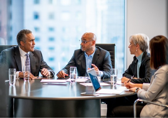 Several business people collaborating at a table during a meeting.