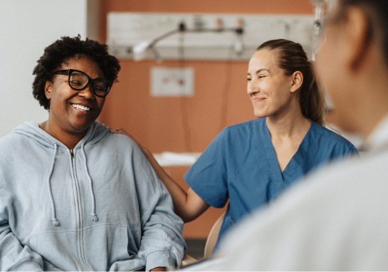 A woman is engaged in conversation with a nurse in a hospital.