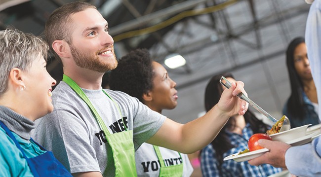 Man handing out food for charity