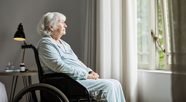 Woman in wheelchair looking out of window