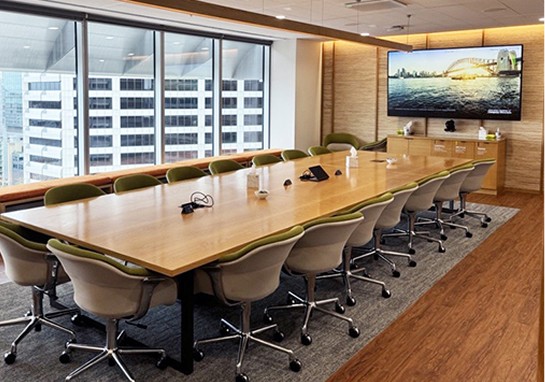 A spacious conference room featuring a large table surrounded by several chairs.