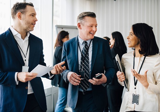 Three business professionals engaged in conversation.