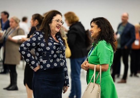 Two women discussing topics of interest at an event.