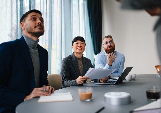 A group of people seated around a table,  for a collaborative work session.