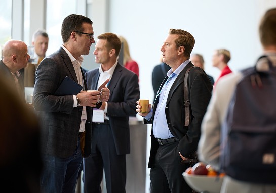 Two men engaged in conversation at a business event.