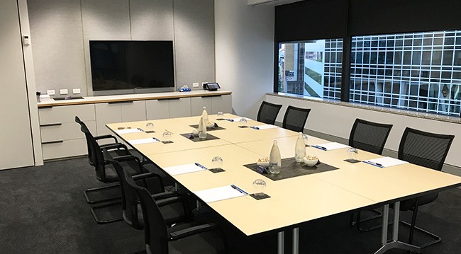 A conference room featuring a large table surrounded by several chairs, designed for meetings and discussions.