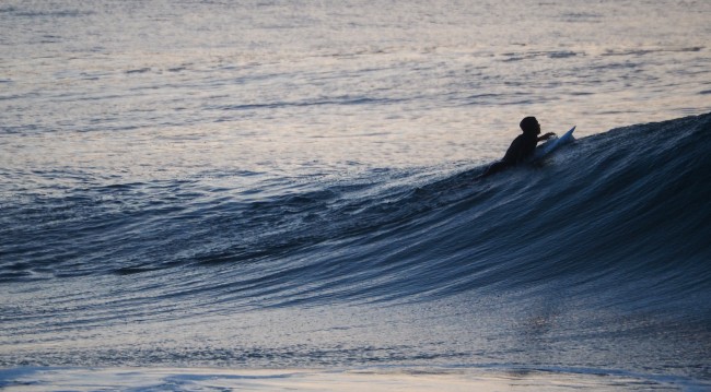 A surfer riding the top of a wave.